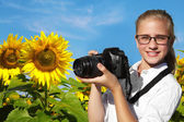 Mladý fotograf a oblast kvetoucí slunečnice