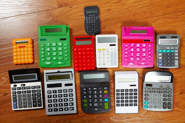 Calculators lying on the wooden flooring — Stock Photo, Image