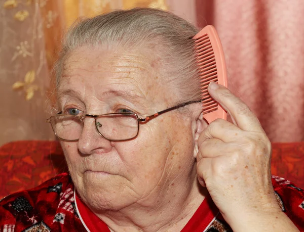 Пожилая женщина и расческа — стоковое фото