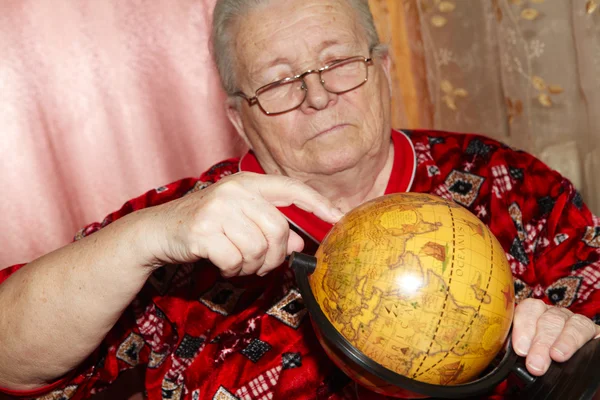 Mulher idosa e globo terrestre — Fotografia de Stock