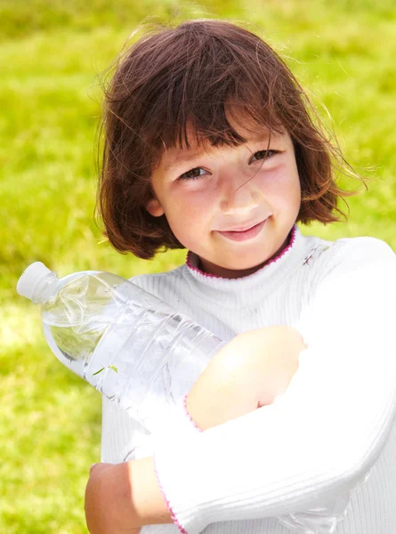 L'enfant tient une bouteille avec de l'eau — Photo