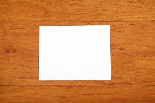Лист паперу на дерев'яній підлозі — стокове фото