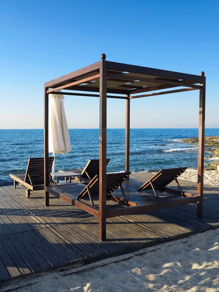 Beach chairs and umbrella on the sand near sea, blue sky — Stock Photo, Image