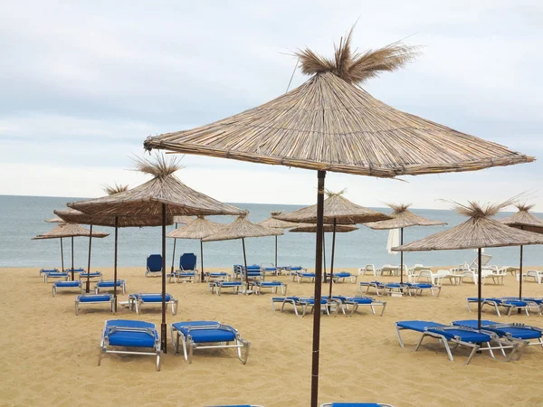 Sillas de playa y sombrilla en la arena cerca del mar, cielo azul —  Fotos de Stock