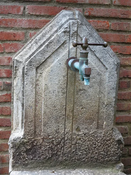 Oude verroeste straat waterpomp op bakstenen muur achtergrond — Stockfoto