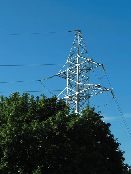 Kraftledning Pylon Över Gröna Träd Och Blå Himmel Bakgrund — Stockfoto