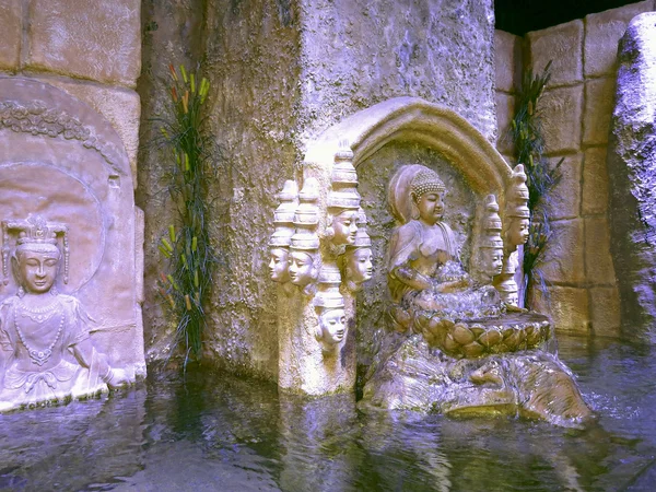 Buddha-Statue aus Stein mit Wasser in einem dekorativen Teich — Stockfoto