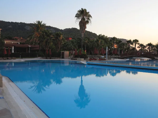 Luxury swimming pool and palms in the tropical hotel in the suns Royalty Free Stock Images