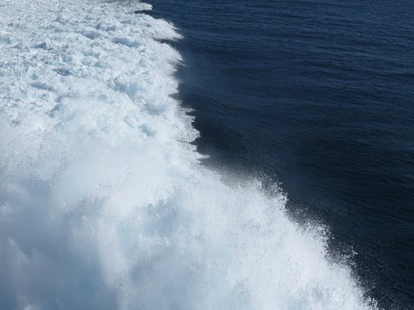 Salpicos de água do mar azul no traço do navio — Fotografia de Stock
