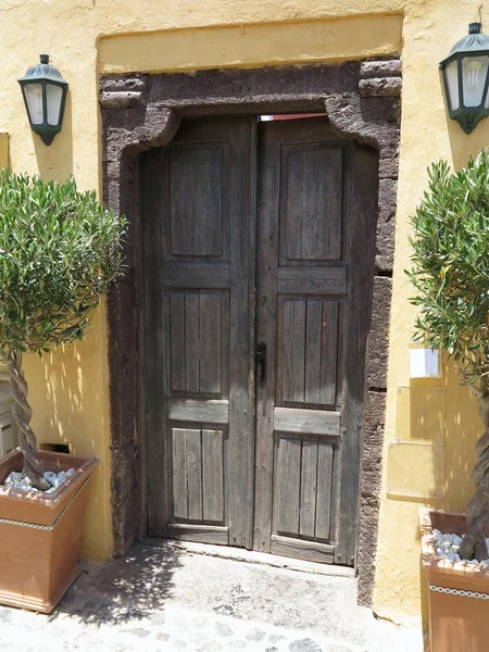 Old brown wooden door and lamps in Greece — Stock Photo, Image