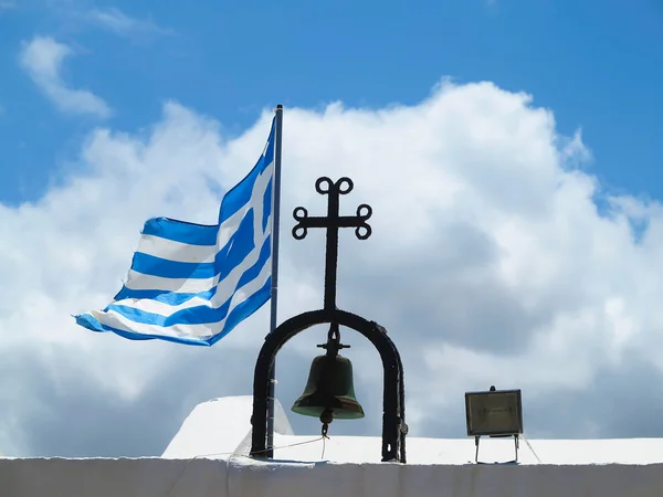La bandera nacional griega cerca de la cruz de la iglesia pequeña contra azul —  Fotos de Stock