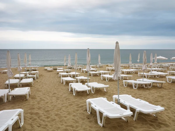 Cadeiras de praia e guarda-chuva na areia perto do mar, céu azul — Fotografia de Stock