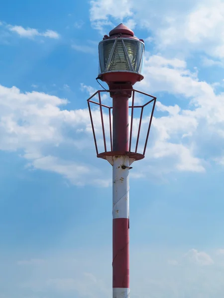Pequeña torre del faro rojo sobre el cielo azul nublado — Foto de Stock