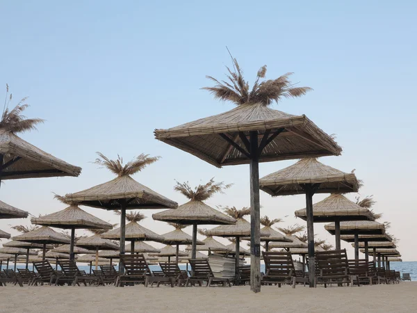 Sillas de playa y sombrilla en la arena cerca del mar, cielo azul — Foto de Stock