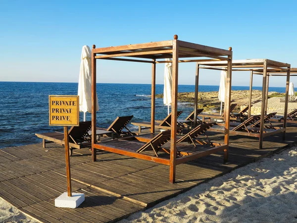 Cadeiras de praia e guarda-chuva na areia perto do mar, céu azul — Fotografia de Stock