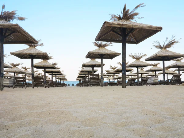 Sillas de playa y sombrilla en la arena cerca del mar, cielo azul — Foto de Stock