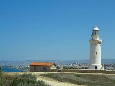 Kıbrıs Rum Kesimi yakınlarındaki mavi gökyüzü üzerinde eski beyaz deniz feneri