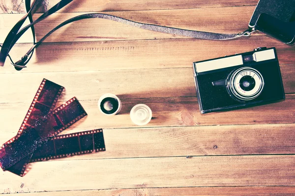 Ретро-винтажная камера и фотопленка на деревянном фоне — стоковое фото