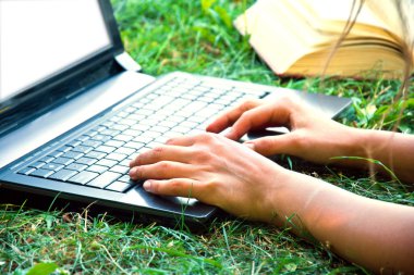 Bir dizüstü bilgisayar açık havada kullanarak el.