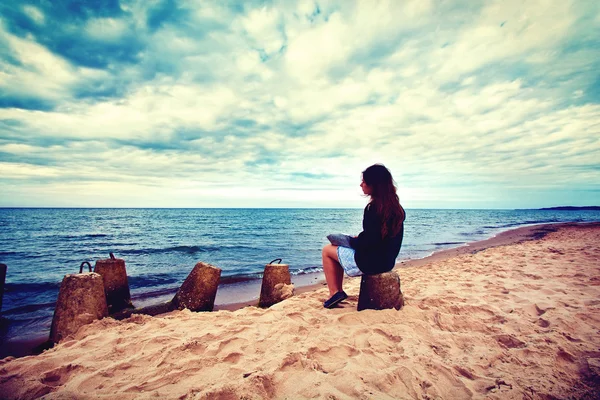 Mujer triste y solitaria sentada en la playa . —  Fotos de Stock