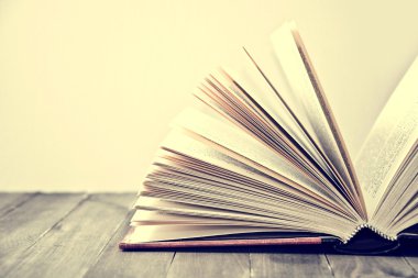 Ahşap masanın üzerinde yatan kitap.