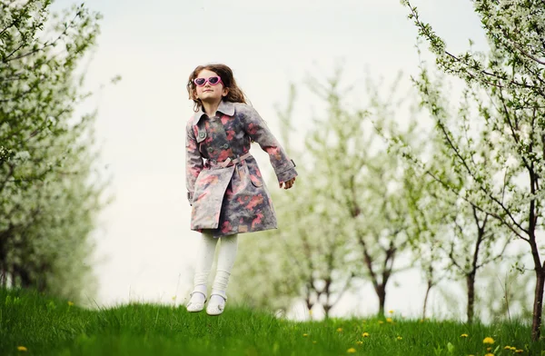 Pequena menina bonita no jardim verde — Fotografia de Stock