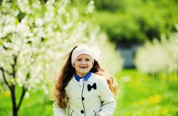 Pequena menina bonita no jardim verde — Fotografia de Stock