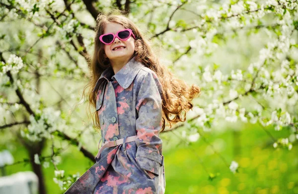 Liten söt flicka i den gröna trädgården — Stockfoto