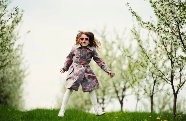 Pequena menina bonita no jardim verde — Fotografia de Stock