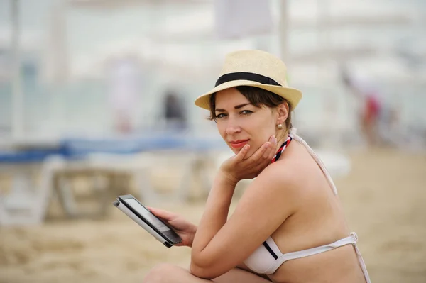 Donna che legge tablet reader sulla spiaggia — Foto Stock
