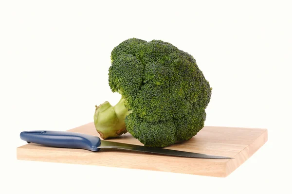 Broccoli with knife on cutting board isolated — Stock Photo, Image