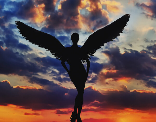 Angel with white wings in the dramatic sky