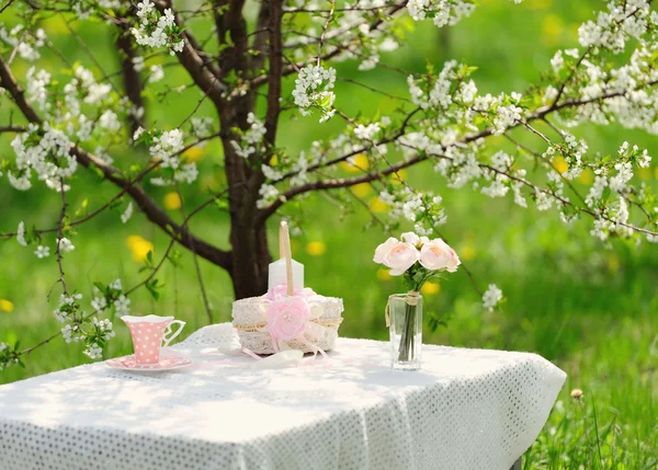 Bouquet de roses et tasse sur la table dans le jardin — Photo