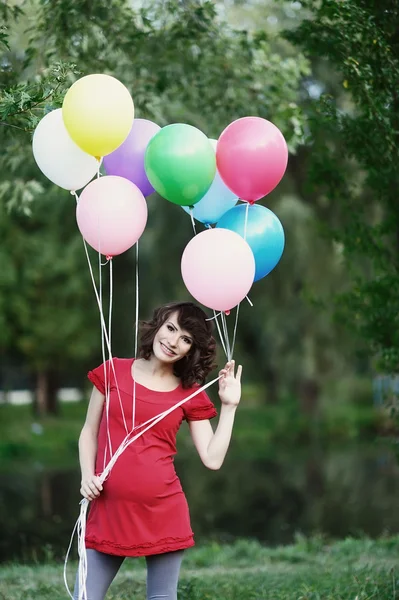 Happy young pregnant woman with balloons in the hands Stock Image