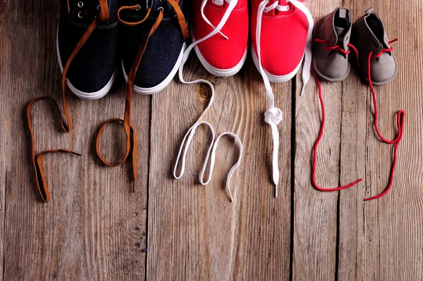 Три пары обуви, представляющие семью, рост, образование и семейные ценности — стоковое фото