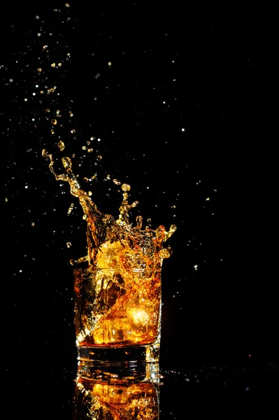 Cognac splashing with ice — Stock Photo, Image