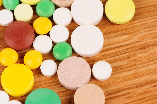 Heap de pílulas na mesa de madeira — Fotografia de Stock