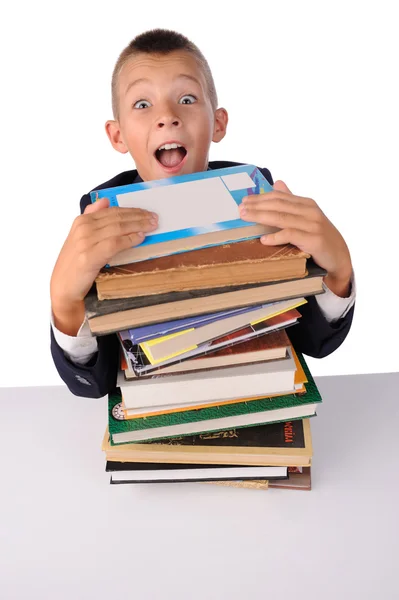 Sorprendido colegial con enorme pila de libros — Foto de Stock