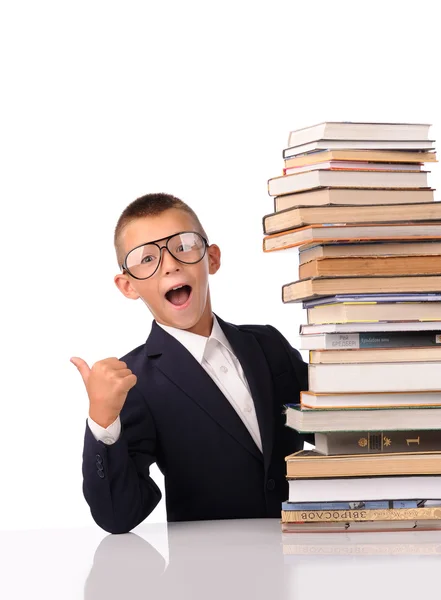 Schooljongen met enorme stapel boeken — Stockfoto