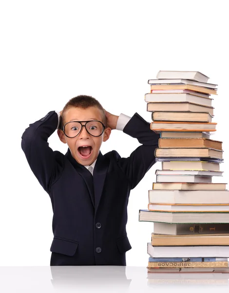 Schoolboy screaming near the huge stack of books — Stock Photo, Image