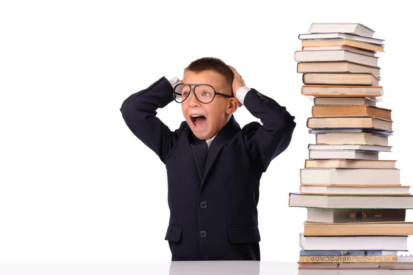 Schoolboy screaming near the huge stack of books — Stock Photo, Image