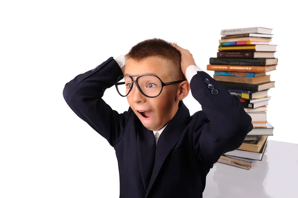 Schoolboy screaming near the huge stack of books — Stock Photo, Image