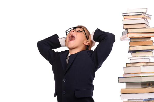 Schoolboy screaming near the huge stack of books — Stock Photo, Image