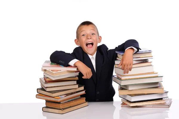 Schoolboy gritando perto da enorme pilha de livros — Fotografia de Stock
