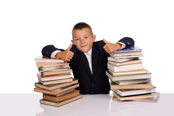 Schooljongen met enorme stapel boeken — Stockfoto