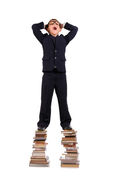 Schoolboy screaming on the huge stack of books — Stock Photo, Image