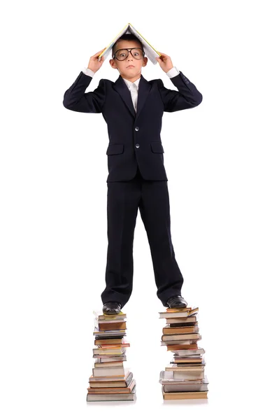 Schoolboy de pé sobre a enorme pilha de livros — Fotografia de Stock