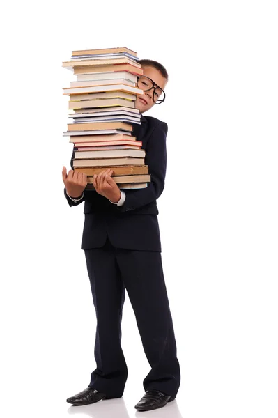 Schooljongen bedrijf enorme stapel boeken — Stockfoto