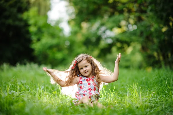 Маленька красива дівчинка в зеленому саду — стокове фото
