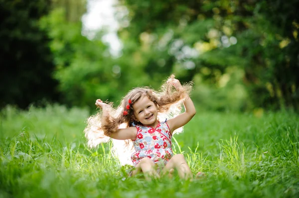 Liten söt flicka i den gröna trädgården — Stockfoto